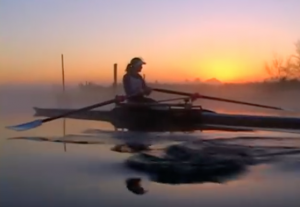 rowing woman with a sunset in the background