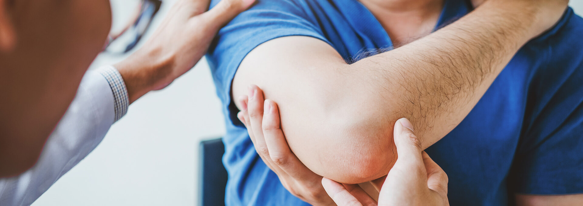 doctor examining a patient with elbow pain