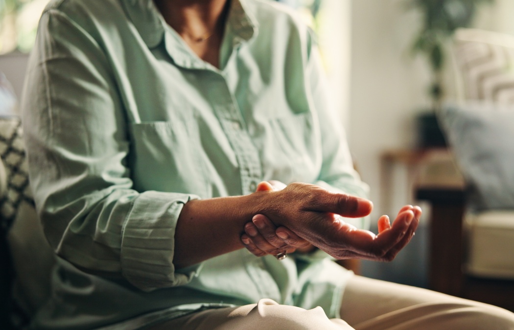 Hands, wrist pain and person with injury, fracture or carpal tunnel syndrome with health in home. Tension, muscle cramp or rheumatoid arthritis with pressure, fibromyalgia and chronic disease