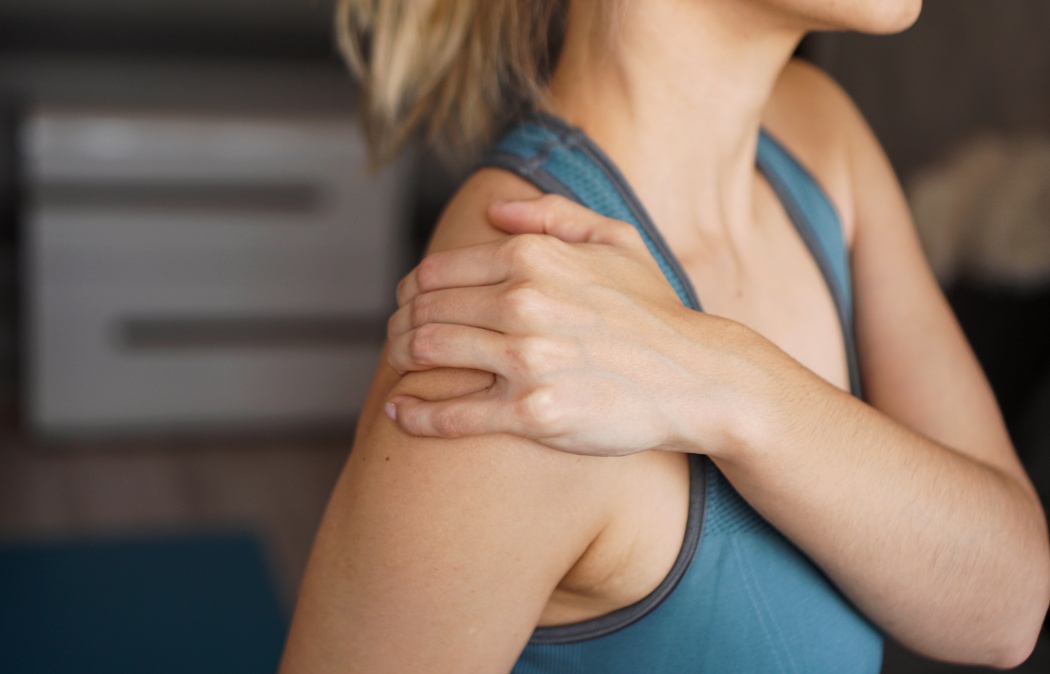 Closeup on fitness woman having pain in shoulder. Pain after home workout